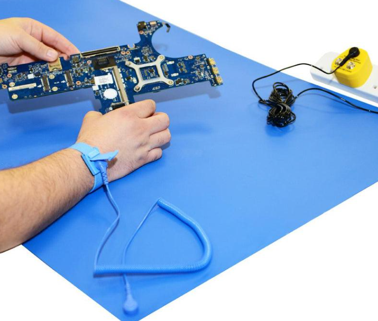 Operator assembling a printed circuit board on a grounded ESD bench mat