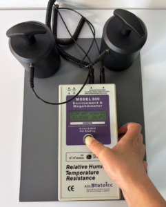 ACL Staticide Model 800 measuring point-to-point resistance on a two-layer ESD bench mat with two weighted electrodes at 150mm spacing