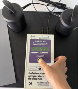ACL Model 800 megohmmeter reading 6.23 x 10 to the 4 ohms on the black conductive layer of an ESD bench mat using two weighted electrodes