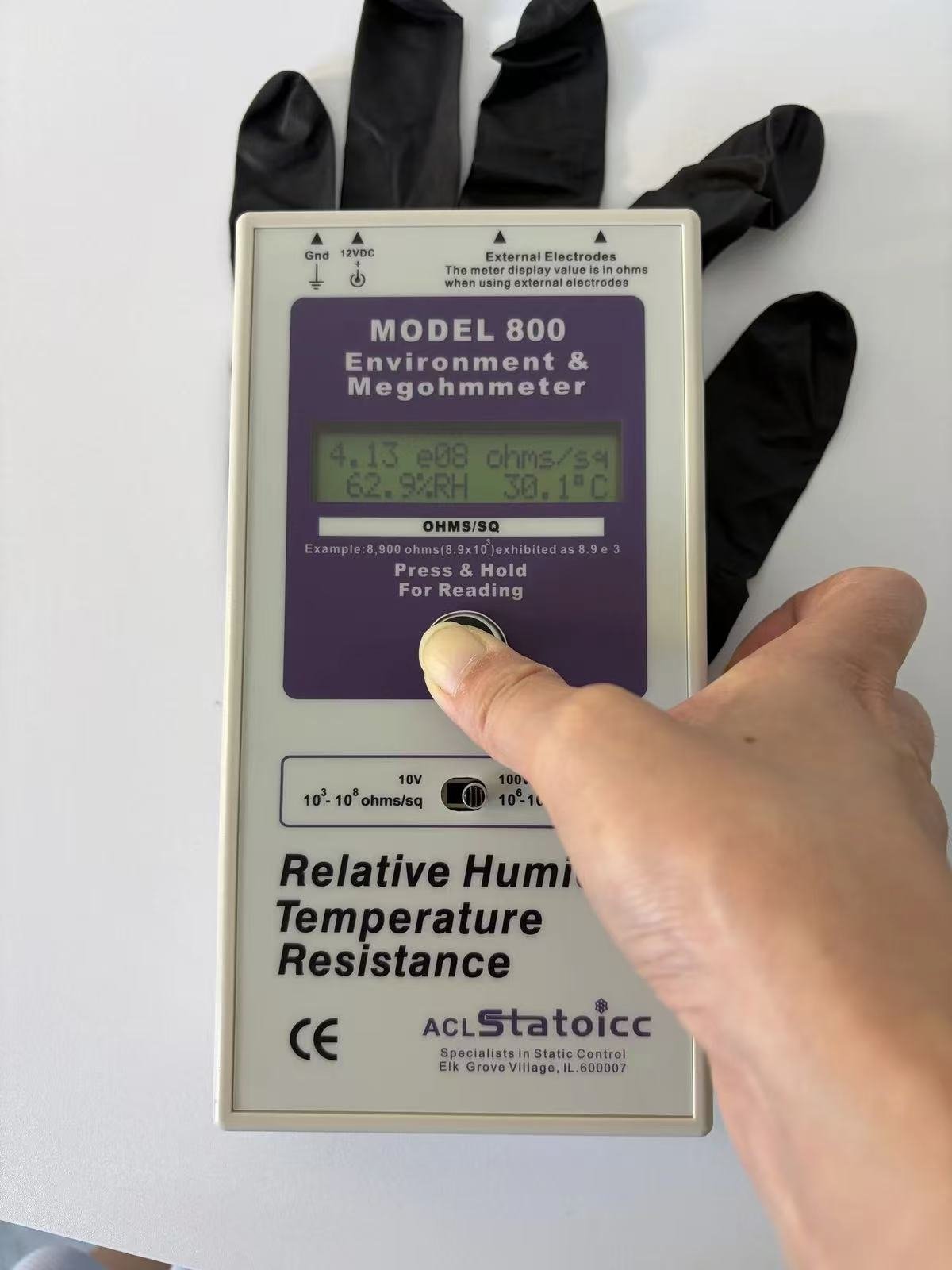 ACL Staticide Model 800 megohmmeter showing 4.13 e08 ohms/sq at 62.9 percent RH and 30.1 degrees C, measuring a black ESD nitrile glove